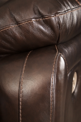 Fashion-forward style. Sumptuous leather feel and appeal. Total comfort at your fingertips. It’s all yours for the taking with the Hallstrung power recliner with adjustable headrest. Wrapped in a lavish chocolate-colored upholstery, this decidedly contemporary power recliner tantalizes the senses in so many ways. Rest assured, the wide seating area is covered in 100% leather for your pleasure, while a skillfully matched faux leather on the exterior makes luxury affordable. Upping the comfort with 44" high back styling, this power recliner truly caters from head to toe. An Easy View™ power adjustable headrest allows you to lean back while propping up your head—perfect for chilling out in front of the TV—while an extended ottoman lets you stretch out all the more. And with a USB port in the power control panel, you hardly have to move a muscle to stay powered up.High-resiliency foam cushions wrapped in thick poly fiber | Corner-blocked frame with metal reinforced seat | One-touch power control with adjustable positions | 44" high back design | Attached back and seat cushions | Easy View™ power adjustable headrest | Extended ottoman for enhanced comfort | Leather interior upholstery; polyester/vinyl exterior upholstery | Includes USB charging port in each power control | Power cord included; UL Listed | Estimated Assembly Time: 15 Minutes