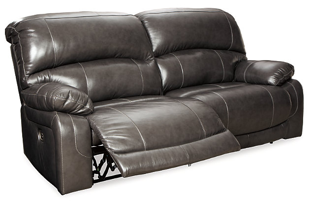 Fashion-forward style. Sumptuous leather feel and appeal. Total comfort at your fingertips. It’s all yours for the taking with the Hallstrung power reclining sofa. Wrapped in a rich charcoal gray upholstery, this decidedly contemporary power sofa tantalizes the senses in so many ways. Rest assured, the seating area is covered in 100% leather for your pleasure, while a skillfully matched faux leather on the exterior makes luxury affordable. Upping the comfort with 44" high back styling, this power sofa truly caters from head to toe. An Easy View™ power adjustable headrest allows you to lean back while propping up your head—perfect for chilling out in front of the TV—while an extended ottoman lets you stretch out all the more. And with a USB port in each power control panel, you hardly have to move a muscle to stay powered up.Dual-sided recliner | One-touch power control recliners with adjustable positions | Includes USB charging port in each power control | Corner-blocked frames with metal reinforced seats | Attached backs and seat cushions | High-resiliency foam cushions wrapped in thick poly fiber | Easy View™ power adjustable headrests | Extended ottomans for enhanced comfort | 100% genuine top-grain leather throughout the seating areas and armrests | High quality leather substitute covers remaining areas | Power cord included; UL Listed | Estimated Assembly Time: 15 Minutes