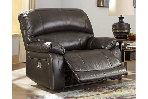 Fashion-forward style. Sumptuous leather feel and appeal. Total comfort at your fingertips. It’s all yours for the taking with the Hallstrung power recliner with adjustable headrest. Wrapped in an attractive gray upholstery, this decidedly contemporary power recliner tantalizes the senses in so many ways. Rest assured, the wide seating area is covered in 100% leather for your pleasure, while a skillfully matched faux leather on the exterior makes luxury affordable. Upping the comfort with 44" high back styling, this power recliner truly caters from head to toe. An Easy View™ power adjustable headrest allows you to lean back while propping up your head—perfect for chilling out in front of the TV—while an extended ottoman lets you stretch out all the more. And with a USB port in the power control panel, you hardly have to move a muscle to stay powered up.High-resiliency foam cushions wrapped in thick poly fiber | Corner-blocked frame with metal reinforced seat | One-touch power control with adjustable positions | 44" high back design | Attached back and seat cushions | Easy View™ power adjustable headrest | Leather interior upholstery; polyester/vinyl exterior upholstery | Extended ottoman for enhanced comfort | Includes USB charging port in the power control | Power cord included; UL Listed | Estimated Assembly Time: 15 Minutes