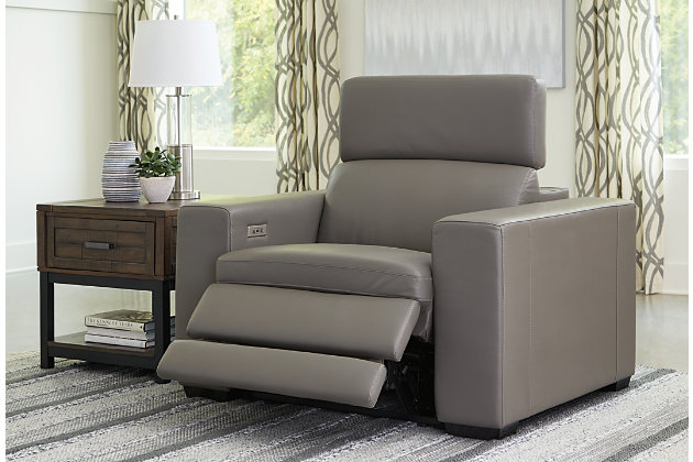 Truly putting high design into recline, the Texline recliner in gray with genuine leather seating area proves that just because you’re a recliner doesn’t mean you have to look like one. Deceptively beautiful, its ultra clean-lined aesthetic is as cool and contemporary as they come. The low-profile back has a super swank look. When you need more support for your head and neck, the press of a button engages the Easy View™ power adjustable headrest, designed to let you lean back and still have a primo view of the TV. To save space, the zero wall design requires minimal space between wall and chair back. Indulgent pillow top seating gives an added layer of comfort.One-touch power control with adjustable positions, Easy View™ adjustable headrest and zero-draw USB plug-in | Zero-draw technology only consumes power when the USB receptacle is in use | Corner-blocked frame with metal reinforced seat | Attached cushions | Pillow top seats | High-resiliency foam cushions wrapped in thick poly fiber | Zero wall design requires minimal space between wall and chair back | Extended ottoman for enhanced comfort | Leather interior upholstery; vinyl/polyester exterior upholstery | Power cord included; UL Listed | Exposed tapered feet
