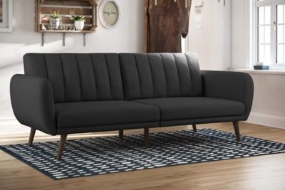 Be embraced by the comfortable cushioning of the Novogratz Brittany linen futon. With its ribbed tufted cushioned back, the Novogratz Brittany Linen futon gives your body all the support you need to sit and relax for hours. The combination of curved armrests and slanted legs work together to provide a unique rounded look that stands out. The linen upholstery adds another element of elegance making this a perfect statement piece for any living space.Stylish linen upholstery wipes clean easily | Ribbed tufted cushioned back with slanted oak coloured wooden legs | Sturdy wood frame construction that is stable and durable | Comfortable polyester and foam filling