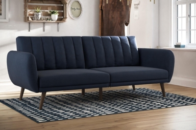 Be embraced by the comfortable cushioning of the Novogratz Brittany linen futon. With its ribbed tufted cushioned back, the Novogratz Brittany Linen futon gives your body all the support you need to sit and relax for hours. The combination of curved armrests and slanted legs work together to provide a unique rounded look that stands out. The linen upholstery adds another element of elegance making this a perfect statement piece for any living space.Stylish linen upholstery wipes clean easily | Ribbed tufted cushioned back | Sturdy wood frame construction | Slanted oak coloured wooden legs