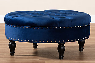 This round ottoman complements your sense of style in a cool, contemporary way. A versatile accent piece, the ottoman doubles as a footrest or impromptu coffee table as the need arises. Upholstered in rich velvet with button tufting and nailhead accents, the elegantly turned legs add classic appeal.Eucalyptus wood frame | Royal blue polyester velvet upholstery | Button tufted with nailhead trim | Black finished legs with non-marking feet | Leg assembly required
