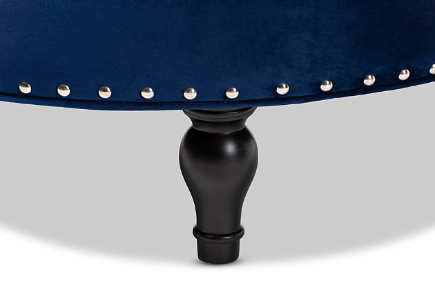 This round ottoman complements your sense of style in a cool, contemporary way. A versatile accent piece, the ottoman doubles as a footrest or impromptu coffee table as the need arises. Upholstered in rich velvet with button tufting and nailhead accents, the elegantly turned legs add classic appeal.Eucalyptus wood frame | Royal blue polyester velvet upholstery | Button tufted with nailhead trim | Black finished legs with non-marking feet | Leg assembly required