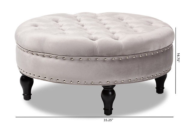 This round ottoman complements your sense of style in a cool, contemporary way. A versatile accent piece, the ottoman doubles as a footrest or impromptu coffee table as the need arises. Upholstered in rich velvet with button tufting and nailhead accents, the elegantly turned legs add classic appeal.Eucalyptus wood frame | Gray polyester velvet upholstery | Button tufted with nailhead trim | Black finished legs with non-marking feet | Leg assembly required