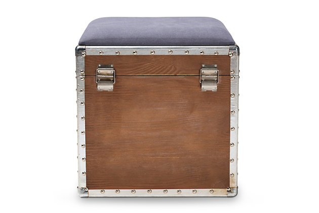 Featuring a striking mix of textures, this ottoman adds character to any space. Cool rivet detailing and an upholstered seat that can be flipped up to reveal an inner storage compartment add a level of interest and abundant practicality. Modeled after vintage storage trunks and accented with silver metal handles, an imitation lock and an antique-inspired inscription, this is sure to be a conversation piece in any room of your home.Made of engineered wood | Light brown finish | Silvertone accents | Gray polyester upholstered seat cushion | Weight capacity 100 pounds | No assembly required