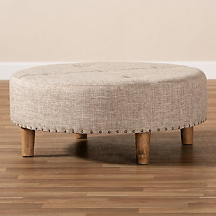 Chic and versatile, this ottoman is designed for the modern home. Upholstered in a soft polyester fabric that displays a subtle cross-hatch weave for a natural earthy feel. The neutral upholstery is complemented by sturdy wood legs showcasing the rustic beauty of the woodgrains. Button tufting on the top and brass-tone nailhead trim along the lower edge add a touch of elegance. Use this versatile ottoman as a coffee table, footstool or extra seating for guests as the need arises.Engineered wood frame | Solid wood legs with natural finish | Beige polyester upholstery | Assembly required