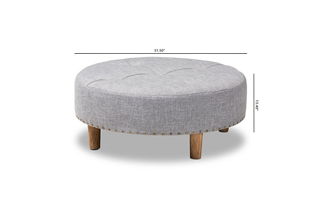 Chic and versatile, this ottoman is designed for the modern home. Upholstered in a soft polyester fabric that displays a subtle cross-hatch weave for a natural earthy feel. The neutral upholstery is complemented by sturdy wood legs showcasing the rustic beauty of the woodgrains. Button tufting on the top and brass-tone nailhead trim along the lower edge add a touch of elegance. Use this versatile ottoman as a coffee table, footstool or extra seating for guests as the need arises.Engineered wood frame | Solid wood legs with natural finish | Light gray polyester upholstery | Assembly required