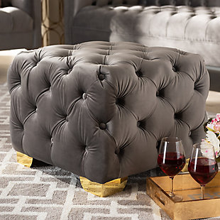 Raise your standard of living with this ottoman upholstered in a soft, sumptuous velvet fabric. Reserved exclusively for those with a penchant for high-glam home decor, this ultra-chic ottoman is dressed to impress with all over button tufting and lustrous goldtone-finished metal feet that simply works. Easy on the eyes and alluring to the touch, this decidedly elegant and versatile ottoman can be used as a coffee table, footstool or as extra seating for guests.Engineered wood frame | Metal feet | Gray velvet upholstery | No assembly required