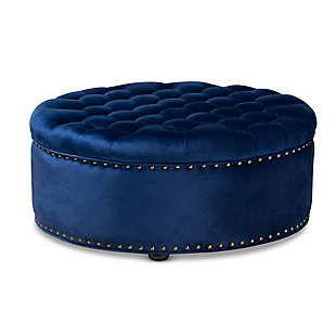 A cut above the rest, this round cocktail ottoman will exceed your expectations. This beautiful living area centerpiece is made with a sturdy wood frame, firm foam cushioning and velvet fabric upholstery. Finishing touches include nailhead trim and wood, non-marking feet.Eucalyptus wood frame | Royal blue velvet upholstery | Antiqued brass-tone nailhead trim | Black finished feet | No assembly required
