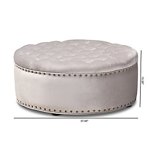 A cut above the rest, this round cocktail ottoman will exceed your expectations. This beautiful living area centerpiece is made with a sturdy wood frame, firm foam cushioning and velvet fabric upholstery. Finishing touches include nailhead trim and wood, non-marking feet.Eucalyptus wood frame | Light gray velvet upholstery | Antiqued brass-tone nailhead trim | Black finished feet | No assembly required