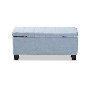 This modern ottoman displays a simple, streamlined design that makes it complementary to a wide range of decor styles. Upholstered in a soft blue fabric, the lid is foam padded and biscuit tufted to provide the utmost comfort. The ottoman features a large compartment under the lid, providing space to store extra blankets and pillows. Finished wood feet complete the look. Versatile enough to use as both seating and storage in the entryway, living room or bedroom.Light blue polyester upholstery | Lift-top storage compartment | Wood feet with black finish | Assembly required