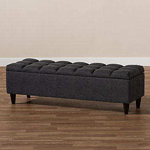 This chic ottoman features a streamlined design that makes it easy to coordinate with a wide range of decor styles. Upholstered in a soft, durable polyester fabric, the lid is foam padded and biscuit tufted to provide the utmost comfort. A large compartment under the lid provides space to store extra blankets and pillows, while the tapered wood legs add mid-century modern appeal. Use this versatile piece in the entryway, living room or bedroom.Gray/beige polyester upholstery | Lift-top storage compartment | Wood legs with dark brown finish | Assembly required