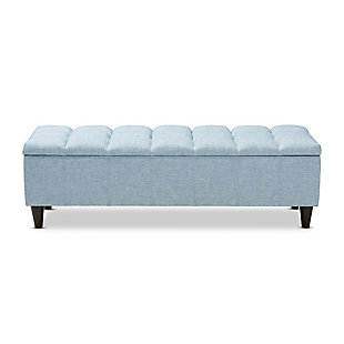 This chic ottoman features a streamlined design that makes it easy to coordinate with a wide range of decor styles. Upholstered in a soft, durable polyester fabric, the lid is foam padded and biscuit tufted to provide the utmost comfort. A large compartment under the lid provides space to store extra blankets and pillows, while the tapered wood legs add mid-century modern appeal. Use this versatile piece in the entryway, living room or bedroom.Light blue polyester upholstery | Lift-top storage compartment | Wood legs with dark brown finish | Assembly required