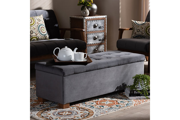 Perfect as a bed end bench for your bedroom or as an accent piece in your living space, the Roanoke storage bench combines handy seating and storage in a stylish way. Constructed with rubberwood, the bench features a cushioned seat upholstered in a soft gray velvet fabric that adds a dose of glamour to your space. The elegant grid-tufted top opens to reveal ample storage space, while walnut brown legs create a strong foundation.Contemporary style | Walnut brown legs | Made of rubberwood, engineered wood, polyester and foam | Upholstered in gray velvet polyester fabric; foam padding | Lift-top storage compartment | Imported | Requires leg assembly