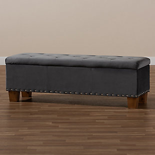 For hidden storage that doubles as seating, opt for the Hannah storage bench. Constructed with rubberwood, the bench is upholstered in a soft gray velvet fabric that adds a dose of glamour to your space. The elegant button-tufted top is padded with foam for seating comfort and opens to reveal ample storage space for extra blankets and linens. Silvertone nailhead trim and walnut-finished block feet lend a chic, modern look. The Hannah is well suited for use as a bed end bench in your bedroom or as an accent piece in your living room.Contemporary style | Made of rubberwood, engineered wood, polyester and foam | Walnut brown legs | Upholstered in gray velvet polyester fabric; foam padding | Lift-top storage compartment | Imported | Requires leg assembly