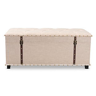 An ottoman, coffee table and storage trunk all in one, the Kyra storage ottoman adds versatility to any space. Set on top of black tapered feet, this ottoman is upholstered in an elegant linen-like fabric and features a cushioned lift-top seat that reveals ample storage space. Inspired by vintage steamer trunks, the Kyra is accented with faux leather straps and brass-tone latches. Goldtone nailheads and button tufting add an extra dose of style.Made of engineered wood and metal | Upholstered in velvet polyester fabric; foam padding | Goldtone nailhead trim; button tufting | Imported | Arrives fully assembled