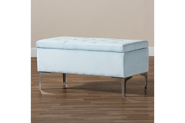 With its functional utility and luxurious style, the Mabel ottoman meets a variety of needs while also looking fabulous. Padded with foam underneath a layer of lavish light blue velvet, this piece is soft to the touch and designed to maximize comfort. The ottoman features elaborate button tufting for a modern look. Raised to a practical height by a silvertone metal leg at each corner, this versatile piece can be used as a footrest or extra seating, while also serving as a storage cabinet for busy areas.Contemporary style | Made of velvet, wood, metal and foam | Silvertone legs | Upholstered in light blue velvet polyester fabric; foam padding | Lift-up storage compartment | Imported | Assembly required