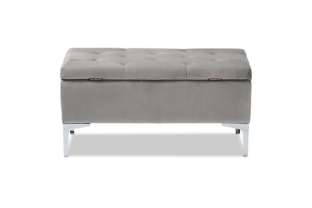 With its functional utility and luxurious style, the Mabel ottoman meets a variety of needs while also looking fabulous. Padded with foam underneath a layer of lavish gray velvet, this piece is soft to the touch and designed to maximize comfort. The ottoman features elaborate button tufting for a modern look. Raised to a practical height by a silvertone metal leg at each corner, this versatile piece can be used as a footrest or extra seating, while also serving as a storage cabinet for busy areas.Contemporary style | Made of velvet, wood, metal and foam | Silvertone legs | Upholstered in gray velvet polyester fabric; foam padding | Lift-up storage compartment | Imported | Assembly required