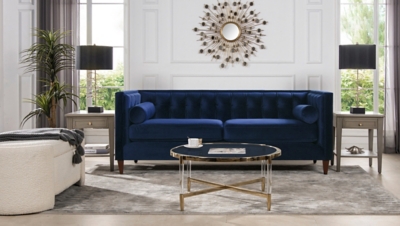 Navy blue sofa in a bright living room with decorative wall mirror