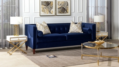 Navy blue sofa in a stylish living room with white walls and gold accents