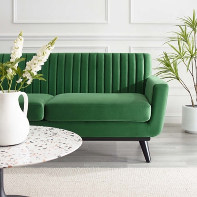 Emerald green sofa in a stylish living room with side plant