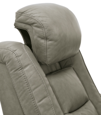 Reserved for him and made for her, The Man-Den power recliner in gray delivers all the comfort and style you could ask for. Inspired by sports car interiors, the seating area is covered in real leather for your pleasure, with a “perforated automotive” treatment for that much more appeal. Positioned at your fingertips, the advanced one-touch power control puts you in the driver’s seat with everything from an Easy View™ power headrest and power lumbar support, to a USB port and wireless charging for your phone. And with an integrated cup holder and hidden storage compartments under the posh, padded armrests, this designer power recliner makes the most of every inch of space.One-touch power control with Easy View™ power adjustable headrest, power lumbar support, USB charging and wireless phone charging | Wireless charger accommodates later model smartphones, including Apple iPhone, Samsung Galaxy, Huawei Mate and Nokia Lumia | Corner-blocked frame with metal reinforced seat | Attached cushions | 43" high back | High-resiliency foam cushions wrapped in thick poly fiber | Leather interior upholstery (with perforated details); vinyl/polyester exterior upholstery | Each armrest includes storage compartment | Cup holder (with 2 layers to accommodate drink containers) | Extended ottoman for enhanced comfort | Nailhead trim | Power cord included; UL Listed | Estimated Assembly Time: 15 Minutes