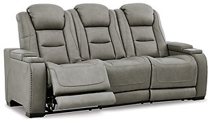 Reserved for him and made for her, The Man-Den power reclining sofa in gray delivers all the comfort and style you could ask for. Inspired by sports car interiors, the seating area is covered in real leather for your pleasure, with a “perforated automotive” treatment for that much more appeal. Positioned at your fingertips, the advanced one-touch power control puts you in the driver’s seat with everything from an Easy View™ power headrest and power lumbar support, to a USB port and wireless charging for your phone. Talk about fully loaded. The middle seat reveals a pull-down table with dimmable reading lights and cup holders. And with integrated cup holders and hidden storage compartments under the posh, padded armrests, this designer power reclining sofa makes the most of every inch of space.Dual-sided recliner | One-touch power control with Easy View™ power adjustable headrest, power lumbar support, USB charging and wireless phone charging | Wireless charger accommodates later model smartphones, including Apple iPhone, Samsung Galaxy, Huawei Mate and Nokia Lumia | Corner-blocked frame with metal reinforced seat | Attached cushions | 43" high back | High-resiliency foam cushions wrapped in thick poly fiber | Leather interior upholstery (with perforated details); vinyl/polyester exterior upholstery | Pull-down table with 2 cup holders (with 2 layers to accommodate drink containers) dimmable reading lights and magazine storage | Each armrest includes storage compartment | Extended ottoman for enhanced comfort | Nailhead trim | Power cord included; UL Listed | Estimated Assembly Time: 15 Minutes