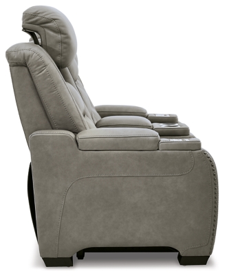 Reserved for him and made for her, The Man-Den power reclining loveseat in gray delivers all the comfort and style you could ask for. Inspired by sports car interiors, the seating area is covered in real leather for your pleasure, with a “perforated automotive” treatment for that much more appeal. Positioned at your fingertips, the advanced one-touch power control puts you in the driver’s seat with everything from an Easy View™ power headrest and power lumbar support, to a USB port and wireless charging for your phone. Talk about fully loaded. And with integrated cup holders and hidden storage compartments under the posh, padded armrests, this designer power reclining loveseat makes the most of every inch of space.Dual-sided recliner | One-touch power control with Easy View™ power adjustable headrest, power lumbar support, USB charging and wireless phone charging | Wireless charger accommodates later model smartphones, including Apple iPhone, Samsung Galaxy, Huawei Mate and Nokia Lumia | Corner-blocked frame with metal reinforced seat | Attached cushions | 43" high back | High-resiliency foam cushions wrapped in thick poly fiber | Leather interior upholstery (with perforated details); vinyl/polyester exterior upholstery | Storage console with 2 cup holders (with 2 layers to accommodate drink containers) | Each armrest includes storage compartment | Extended ottoman for enhanced comfort | Nailhead trim | Power cord included; UL Listed | Estimated Assembly Time: 15 Minutes