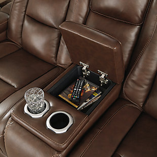 Reserved for him and made for her, this mahogany hued power reclining loveseat delivers all the comfort and style you could ask for. Inspired by sports car interiors, the Man-Den power reclining loveseat with console features real leather in the seating area for your pleasure with high-end accents for that much more appeal. The advanced one-touch power control puts you in the driver’s seat with an adjustable headrest and lumbar support, USB port and wireless charging for your phone, all at your fingertips. The center console includes two illuminated cup holders and a storage compartment. This power recliner makes the most of every inch of space, with hidden storage compartments under the padded armrests.Dual-sided recliner | One-touch power control with Easy View™ power adjustable headrest, power lumbar support, USB charging and wireless phone charging | Wireless charger accommodates later model smartphones, including Apple iPhone, Samsung Galaxy, Huawei Mate and Nokia Lumia | Corner-blocked frame with metal reinforced seat | Attached cushions | High-resiliency foam cushions wrapped in thick poly fiber | Leather interior upholstery (with perforated details); vinyl/polyester exterior upholstery | Storage console with 2 cup holders | 43" high back | Armrest with storage compartment | Extended ottoman for enhanced comfort | Nailhead trim | Power cord included; UL Listed | Estimated Assembly Time: 15 Minutes