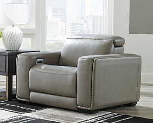Truly putting high design into recline, the Correze power recliner with genuine leather seating area proves that just because you’re a recliner doesn’t mean you have to look like one. Deceptively beautiful, its ultra clean-lined aesthetic is as cool and contemporary as they come. Low-profile back has a super swank look. When you need more support for your head and neck, the press of a button engages the Easy View™ power adjustable headrest, designed to let you lean back and still have a primo view of the TV. Ever-so-subtle curves and stunning stitching perfect the aesthetic.Includes 2 pieces: right-arm facing arm and left-arm facing zero wall power recliner | One-touch power control with adjustable positions, Easy View™ adjustable headrest and zero-draw USB plug-in | Zero-draw technology only consumes power when the USB receptacle is in use | Zero wall design requires minimal space between wall and chair back | Corner-blocked frame with metal reinforced seat | Attached back and seat cushions | High-resiliency foam cushions wrapped in thick poly fiber | Extended ottoman for enhanced comfort | Leather interior upholstery; vinyl/polyester exterior upholstery | Power cord included; UL Listed | Exposed feet with faux wood finish | Estimated Assembly Time: 35 Minutes