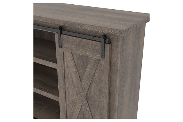 With its replicated weathered oak finish, cross-buck details and authentic charm, the Arlenbry TV stand is right in tune with your relaxed approach to high style. Beautifully made to accommodate your media equipment, it’s well equipped with adjustable shelving, cutouts for wire management and, of course, a pair of sliding barn doors you can center or place to the side. What a mastery in modern farmhouse living.Made of engineered wood and decorative laminate | Replicated weathered oak grain | Metal brackets and hardware | 2 adjustable center shelves; 4 side shelves | Pair of sliding barn doors | Cross-buck details | Cutouts for wire management | Assembly required | Estimated Assembly Time: 90 Minutes