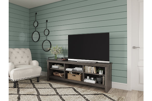With its replicated weathered oak finish and minimalist charm, the Arlenbry TV stand is right in tune with your relaxed approach to high style. Beautifully made to accommodate your media equipment, it’s well equipped with a flexible, open-concept design and cutouts for wire management that enhance the clean-lined aesthetic. The look is ideal for modern farmhouse and contemporary settings.Made of engineered wood and decorative laminate | Replicated weathered oak grain | 3 shelves (6 open compartments) | Cutouts for wire management | Assembly required | Estimated Assembly Time: 30 Minutes