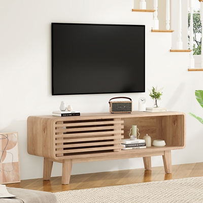 TV on wooden console with open right shelf and minimal decor.