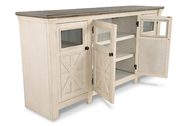 Whether your style is farmhouse fresh, shabby chic or country cottage, you’ll find the Bolanburg extra large TV stand perfectly in tune. Its two-tone, gently distressed finish pairs weathered oak with antique white for that much more quaint character. Charming elements include crossbuck adorned cabinets with glass inlays for peek-through flair. Ample adjustable shelving and cutouts for wire management nicely accommodate your media needs.Made of veneers, wood and engineered wood | Two-tone finish (weathered oak top over antique white) | 2 side cabinets with 2 adjustable shelves each | 1 center cabinet with 2 doors and 2 adjustable shelves | Cabinet doors with glass inlays | Black faceted hardware | Cutouts for wire management | Assembly required | Estimated Assembly Time: 30 Minutes