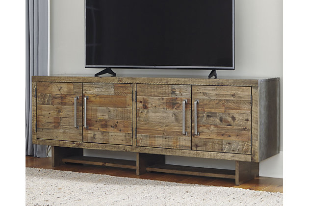 Get a double take on rustic beauty and functionality with the Mozanburg 72-inch TV stand. Its extra wide design captivates with two spacious double door cabinets. Shelf storage and cutouts for wires are concealed behind cabinet doors. A light brown glaze accentuates the pine wood features seen on the planked door fronts. Industrial elements, such as its faux metal top/sides, lengthy cabinet handles and nailhead trim add modern charm—what a stylish addition for entertaining at home.Made of engineered wood | Rustic gray/brown finish | Silvertone hardware | 2 cabinets with double doors, shelf storage | Faux metal top and sides | Nailhead trim | Cutouts for wire management | Assembly required | Estimated Assembly Time: 60 Minutes