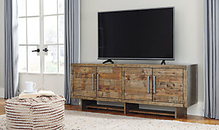 Get a double take on rustic beauty and functionality with the Mozanburg 72-inch TV stand. Its extra wide design captivates with two spacious double door cabinets. Shelf storage and cutouts for wires are concealed behind cabinet doors. A light brown glaze accentuates the pine wood features seen on the planked door fronts. Industrial elements, such as its faux metal top/sides, lengthy cabinet handles and nailhead trim add modern charm—what a stylish addition for entertaining at home.Made of engineered wood | Rustic gray/brown finish | Silvertone hardware | 2 cabinets with double doors, shelf storage | Faux metal top and sides | Nailhead trim | Cutouts for wire management | Assembly required | Estimated Assembly Time: 60 Minutes