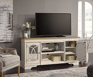 Elevating the art of traditional cottage styling, the Realyn TV stand with fireplace option is beautifully in tune with your taste. Antiqued two-tone aesthetic blends a chipped white with a distressed wood tone top for added charm. Cabinet doors’ decorative fretwork over mirrored glass adds a lovely twist. Compatible with W100-121 fireplace insert (sold separately).Made of wood, engineered wood and veneers | Antiqued two-tone finish | Removable center shelf | Pair of cabinet doors inset mirrored glass and decorative fretwork | Each cabinet includes single-shelf storage | Dark bronze-tone finished metal hardware | Cutouts for wire management and ventilation | Compatible with W100-121 fireplace insert (sold separately) | Assembly required | Estimated Assembly Time: 60 Minutes