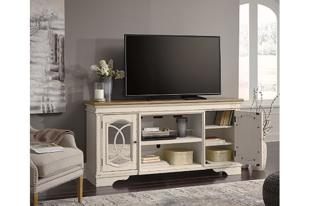 Elevating the art of traditional cottage styling, the Realyn TV stand with fireplace option is beautifully in tune with your taste. Antiqued two-tone aesthetic blends a chipped white with a distressed wood tone top for added charm. Cabinet doors’ decorative fretwork over mirrored glass adds a lovely twist. Compatible with W100-121 fireplace insert (sold separately).Made of wood, engineered wood and veneers | Antiqued two-tone finish | Removable center shelf | Pair of cabinet doors inset mirrored glass and decorative fretwork | Each cabinet includes single-shelf storage | Dark bronze-tone finished metal hardware | Cutouts for wire management and ventilation | Compatible with W100-121 fireplace insert (sold separately) | Assembly required | Estimated Assembly Time: 60 Minutes